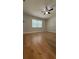 Bright bedroom featuring hardwood floors, ceiling fan, and large window at 6428 Lynn Rd, Orlando, FL 32810