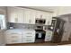 Updated kitchen with stainless steel appliances, modern backsplash, and white cabinetry with bronze hardware at 6428 Lynn Rd, Orlando, FL 32810