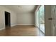 Bright living room with sliding doors leading to a fenced backyard and wood-look floors at 6428 Lynn Rd, Orlando, FL 32810