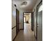 Hallway with tiled floor, bright chandelier, and multiple doors, showcasing access to various rooms at 6616 Blanche Ct, Orlando, FL 32818