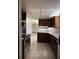 Well-equipped kitchen featuring brown cabinetry, stainless steel appliances, and tiled flooring at 6616 Blanche Ct, Orlando, FL 32818