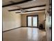 Open living space with tiled floors, ceiling beams, ceiling fan, and sliding doors to the outdoor area at 6616 Blanche Ct, Orlando, FL 32818
