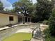 Backyard view of inground pool needing repair and cleaning, with screen patio at 6616 Blanche Ct, Orlando, FL 32818
