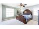 Comfortable bedroom with carpet flooring, featuring a large window, and ceiling fan, providing ample natural light and ventilation at 765 Coach Light Dr, Casselberry, FL 32730