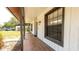 Spacious front porch featuring a swing, brick flooring, and stylish fixtures at 765 Coach Light Dr, Casselberry, FL 32730