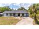 Inviting single-story home with mature landscaping and a charming, covered porch at 765 Coach Light Dr, Casselberry, FL 32730