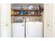 Convenient laundry room equipped with modern washer and dryer, shelving for storage, and ample space for organization at 765 Coach Light Dr, Casselberry, FL 32730