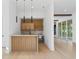 An indoor bar features a wooden facade, open shelving, mini fridge, and pendant lighting for a modern design at 7706 Ficquette Rd, Windermere, FL 34786