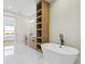 Bright bathroom featuring a soaking tub, marble floors, and a light wood vanity with ample storage at 7706 Ficquette Rd, Windermere, FL 34786
