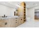 Bright bathroom with double vanity, marble counters, a free-standing tub, open shelving, and marble flooring at 7706 Ficquette Rd, Windermere, FL 34786