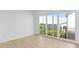 Bright bedroom with wood floors, a large window, and a balcony overlooking a lush yard and lake at 7706 Ficquette Rd, Windermere, FL 34786