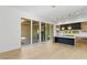 Modern open-concept kitchen featuring wood floors, a large island, and sliding doors to an outdoor space at 7706 Ficquette Rd, Windermere, FL 34786