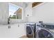 Well-lit laundry room with modern appliances, a sink, and ample storage, perfect for convenience at 7706 Ficquette Rd, Windermere, FL 34786