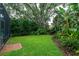Lush backyard featuring manicured lawn and tropical landscaping at 8335 Lake Burden Circle, Windermere, FL 34786