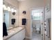 Bathroom with dual sinks, ample lighting, and a separate toilet room for added convenience at 8335 Lake Burden Circle, Windermere, FL 34786