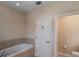 Bright bathroom featuring a soaking tub and a convenient door to a private toilet room at 8335 Lake Burden Circle, Windermere, FL 34786
