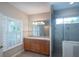 Bright bathroom with double vanity, glass shower, and plantation shutters for natural light and privacy at 8335 Lake Burden Circle, Windermere, FL 34786