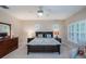 Well-lit bedroom with a ceiling fan, large windows, and a comfortable bed with stylish pillows at 8335 Lake Burden Circle, Windermere, FL 34786