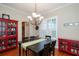 Traditional dining room featuring a dark wood table, red cabinets and a modern light fixture at 8335 Lake Burden Circle, Windermere, FL 34786