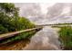 Scenic view of a wooden dock extending into a tranquil lake with lush vegetation at 8335 Lake Burden Circle, Windermere, FL 34786