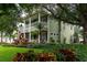 Two-story home featuring a well-manicured lawn with lush garden beds and mature trees at 8335 Lake Burden Circle, Windermere, FL 34786