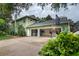 Back exterior featuring multi-car garage, basketball hoop, and mature landscaping for outdoor recreation at 8335 Lake Burden Circle, Windermere, FL 34786