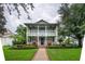 Inviting two-story home with a lush lawn, charming front porch, and symmetrical landscaping at 8335 Lake Burden Circle, Windermere, FL 34786