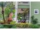 Charming covered front porch with ceiling fans and comfortable seating amidst lush tropical landscaping at 8335 Lake Burden Circle, Windermere, FL 34786