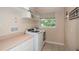 Bright laundry room featuring modern washer and dryer, countertop space, and a window with a view at 8335 Lake Burden Circle, Windermere, FL 34786
