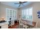 Bright office with ample natural light from shuttered windows, featuring a desk, seating, and wooden floors at 8335 Lake Burden Circle, Windermere, FL 34786