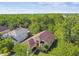 Aerial view of a charming home with lush surrounding trees and a peek of a lake at 848 Magnolia Creek Cir, Orlando, FL 32828