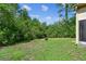 Landscaped backyard with a fire pit surrounded by lush greenery at 848 Magnolia Creek Cir, Orlando, FL 32828