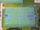 Aerial view of a basketball court, with blue and green coloring, and surrounded by green grass and trees at 848 Magnolia Creek Cir, Orlando, FL 32828