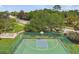 Green basketball court with exercise equipment, mature trees, and a nearby street at 848 Magnolia Creek Cir, Orlando, FL 32828