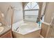 Bright bathroom featuring a garden tub with bamboo decor and a large arched window at 848 Magnolia Creek Cir, Orlando, FL 32828