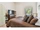 Comfortable bedroom with a window, brown comforter, decorative pillows, and dresser at 848 Magnolia Creek Cir, Orlando, FL 32828