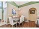 Dining room with hardwood floors, neutral paint, and an archway into the living area at 848 Magnolia Creek Cir, Orlando, FL 32828