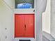 Close-up of a bright red double front door with transom window above at 848 Magnolia Creek Cir, Orlando, FL 32828