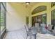 Screened-in patio featuring a tile floor, ceiling fan, and table set for outdoor dining at 848 Magnolia Creek Cir, Orlando, FL 32828