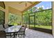 Screened patio with tile floor, glass-top table, and backyard views at 848 Magnolia Creek Cir, Orlando, FL 32828
