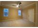 Large bedroom with a ceiling fan, neutral carpeting, and two windows for plenty of natural light at 8608 Falstaff Pl, Oviedo, FL 32765
