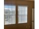 Bedroom with beige walls, carpet, and windows with white vertical blinds at 8608 Falstaff Pl, Oviedo, FL 32765