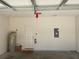A clean, organized garage interior featuring a water heater, fire extinguisher, and electrical panel at 8608 Falstaff Pl, Oviedo, FL 32765