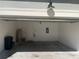 Spacious garage with a white door, overhead lighting, and storage area at 8608 Falstaff Pl, Oviedo, FL 32765