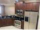 Well-equipped kitchen with stainless steel appliances, granite countertops, and wood cabinets at 8608 Falstaff Pl, Oviedo, FL 32765