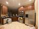 Modern kitchen with stainless steel appliances, granite countertops, and wood cabinets at 8608 Falstaff Pl, Oviedo, FL 32765