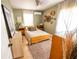 Light-filled bedroom with sage walls, wood bed frame, and rustic wall decor at 920 Timor Ave, Orlando, FL 32804
