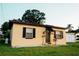 View of a single story home with green lawn, rock landscaping and black shutters at 920 Timor Ave, Orlando, FL 32804