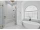 Elegant bathroom showcasing a luxurious tub and shower with glass enclosure and gold hardware at 9259 Tibet Pointe Cir, Windermere, FL 34786