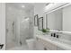 Modern bathroom with marble shower, frameless glass door, and a large, lighted mirror at 9259 Tibet Pointe Cir, Windermere, FL 34786